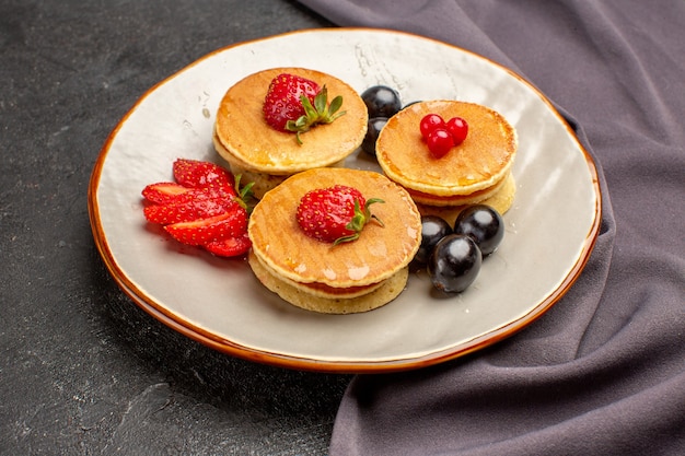 Foto gratuita vista frontal deliciosos panqueques con aceitunas y frutas en la superficie oscura pastel dulce de frutas