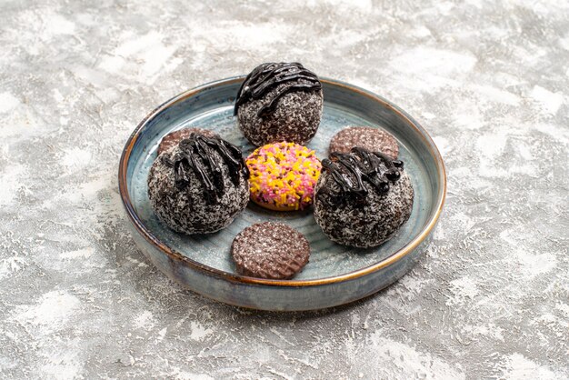 Foto gratuita vista frontal deliciosos pasteles de bolas de chocolate con galletas en el espacio en blanco