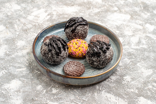 Vista frontal deliciosos pasteles de bolas de chocolate con galletas en el espacio en blanco