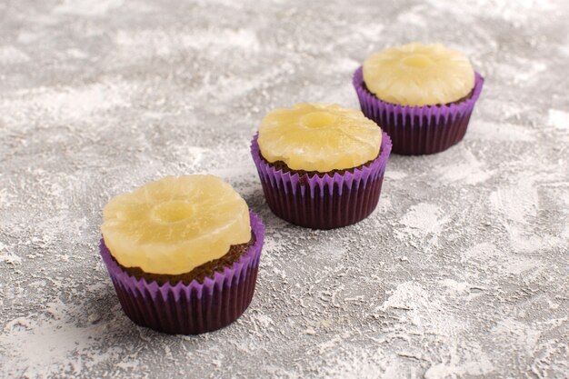 Vista frontal deliciosos pasteles de chocolate con anillos de piña en la mesa de luz pastel dulce masa para hornear