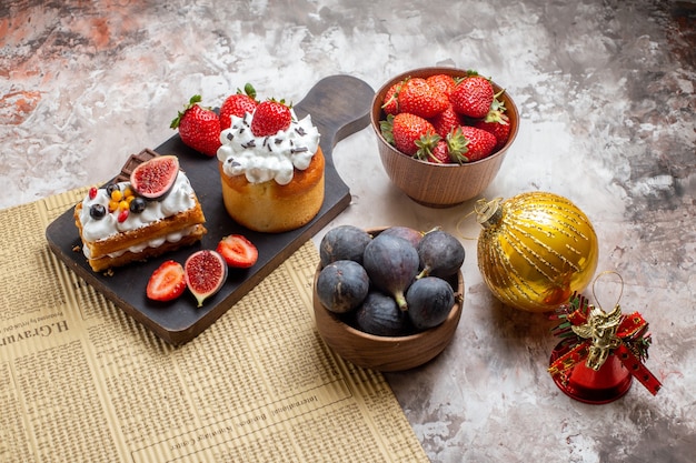 Foto gratuita vista frontal deliciosos pasteles con frutas frescas sobre fondo claro pastel de navidad postre color galleta