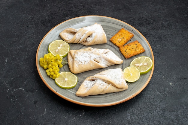 Vista frontal deliciosos pasteles de masa de azúcar en polvo en la pared de color gris oscuro pastelería hornear galletas de pastel dulce de azúcar