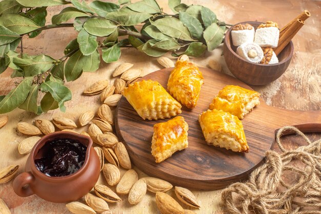 Vista frontal de deliciosos pasteles de nueces con nueces sobre superficie de madera