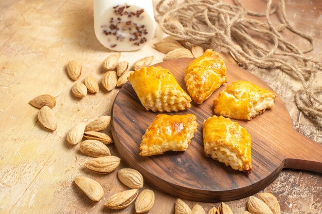 Vista frontal de deliciosos pasteles de nueces con nueces sobre superficie de madera