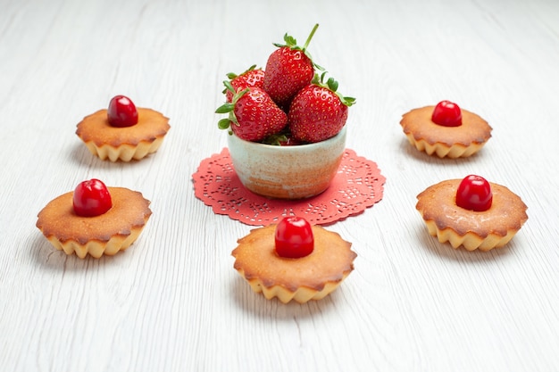 Vista frontal deliciosos pasteles en el postre de galletas de pastel de escritorio blanco dulce