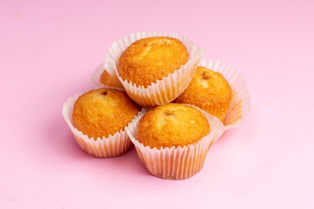 Vista frontal deliciosos pasteles con relleno de frutas en el fondo rosa pastel galleta galleta dulce azúcar té