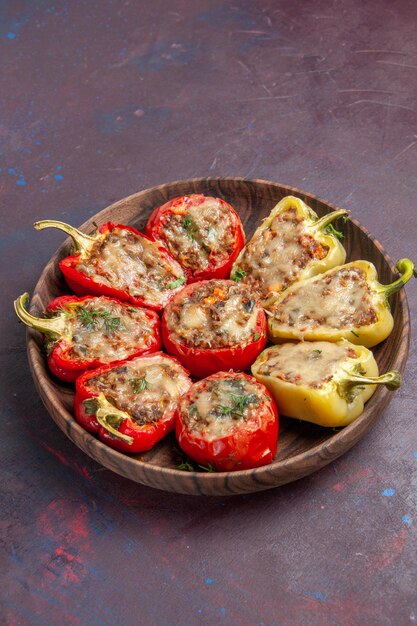 Vista frontal deliciosos pimientos plato cocido con carne sobre fondo oscuro plato de cena hornear carne comida sal