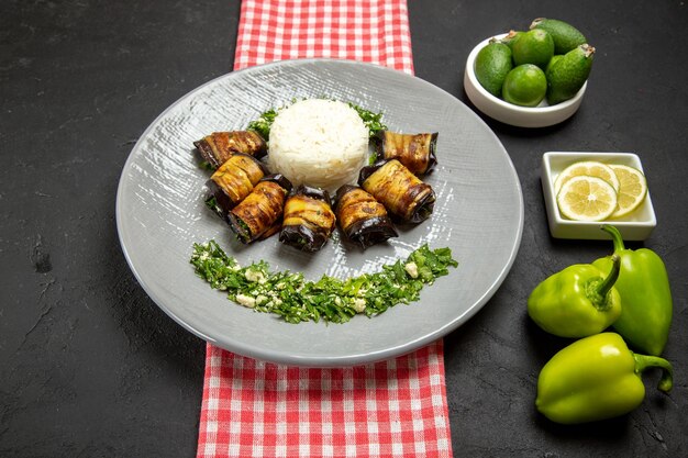 Vista frontal deliciosos rollos de berenjena plato cocido con arroz y diferentes ingredientes en la superficie oscura cocinando arroz planta comida cocina