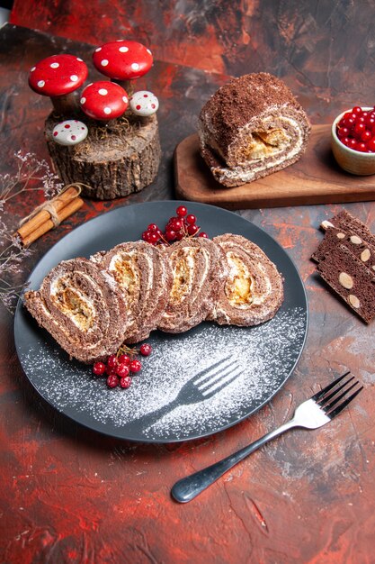 Vista frontal de deliciosos rollos de galletas dentro de la placa sobre una superficie oscura