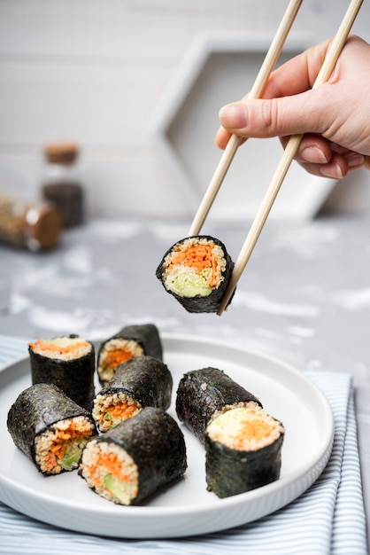 Foto gratuita vista frontal deliciosos rollos de sushi y fondo borroso