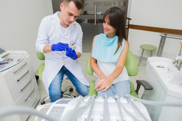 Vista frontal del dentista y paciente con equipo