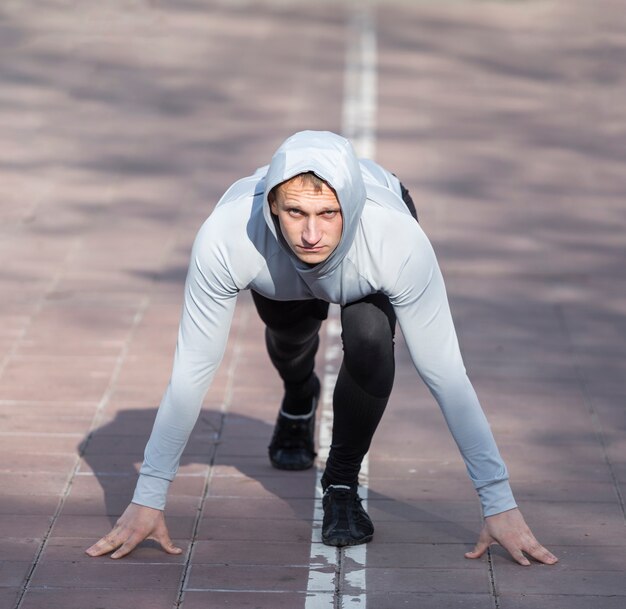 Vista frontal deportivo hombre preparándose para correr