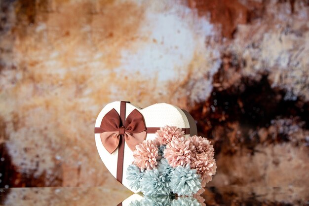 Vista frontal del día de San Valentín con flores sobre fondo marrón claro color sentimiento familiar belleza pareja pasión amor corazón