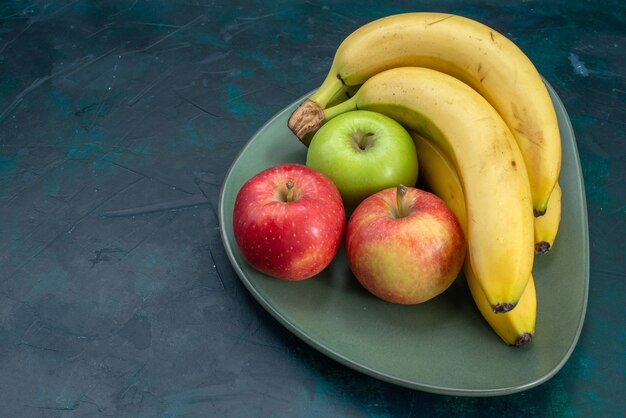 Vista frontal diferente composición de frutas manzanas y plátanos en el escritorio azul oscuro fruta tropical exótica suave fresca