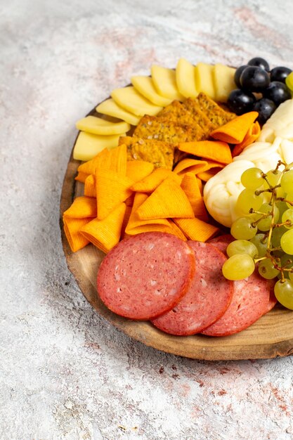 Vista frontal diferentes bocadillos cips salchichas queso y uvas frescas en espacio en blanco