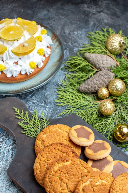 Vista frontal diferentes deliciosas galletas con pastel en la superficie claro-oscura