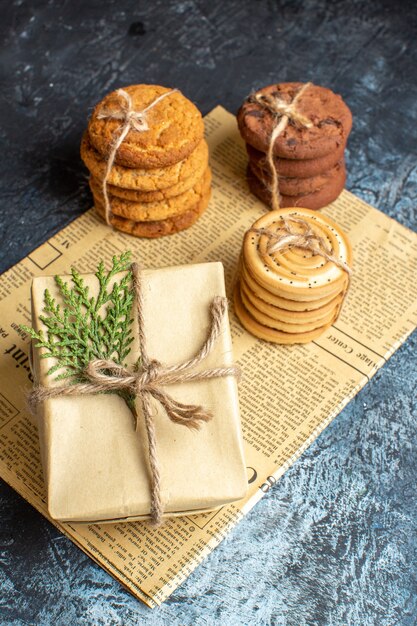 Vista frontal diferentes deliciosas galletas con presente sobre fondo claro