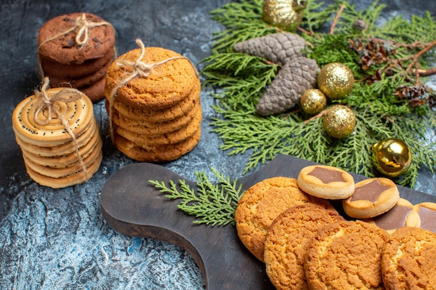 Vista frontal diferentes deliciosas galletas en superficie claro-oscura