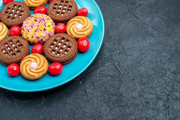 Vista frontal diferentes galletas de azúcar con caramelos sobre una superficie gris galletas de galletas de té dulce de azúcar dulce