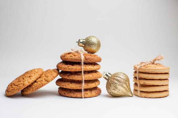 Vista frontal diferentes sabrosas galletas sobre fondo blanco.