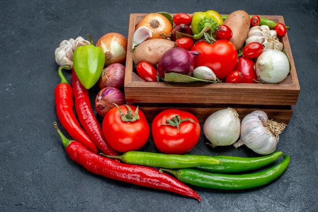 Vista frontal de diferentes verduras frescas en la mesa oscura ensalada de color maduro fresco