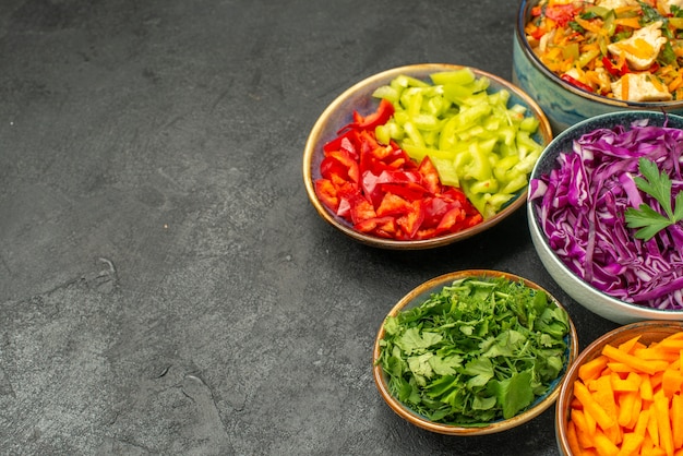 Vista frontal de diferentes verduras en rodajas con ensalada de pollo en la dieta saludable de la mesa oscura