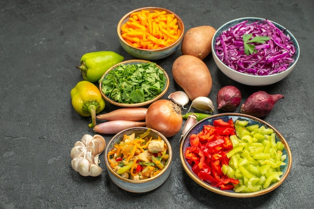 Foto gratuita vista frontal de diferentes verduras en rodajas con verduras en la dieta de comida saludable de mesa oscura