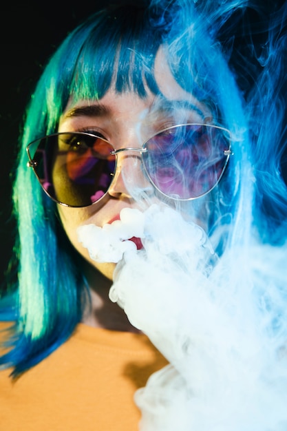 Foto gratuita vista frontal dj femenino con gafas de sol fumando