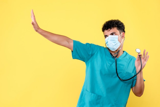 Foto gratuita vista frontal del doctor el doctor en máscara con fonendoscopio en el uniforme médico azul