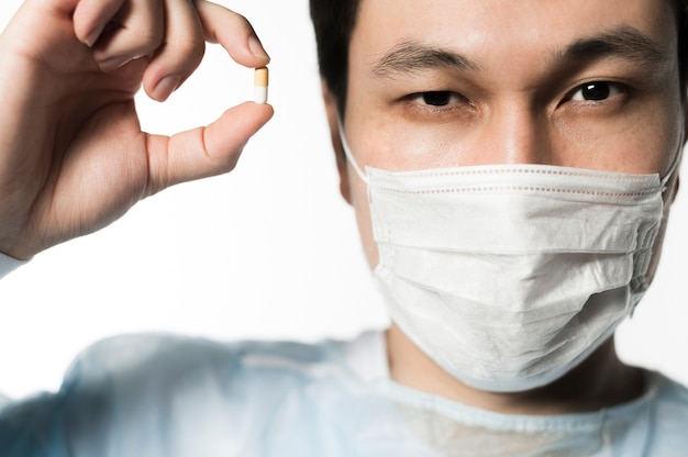 Foto gratuita vista frontal del doctor sosteniendo una pastilla