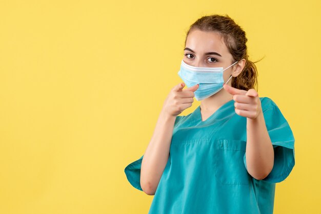 Vista frontal doctora en camisa y máscara médica, virus uniforme color de salud covid-19 coronavirus