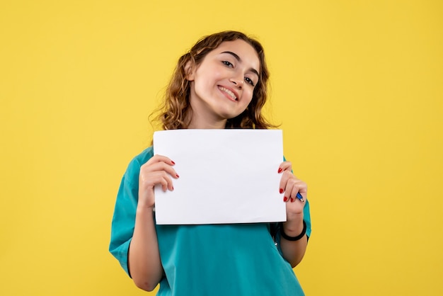 Vista frontal doctora en camisa médica con análisis de papel, emoción uniforme del virus pandémico covid-19