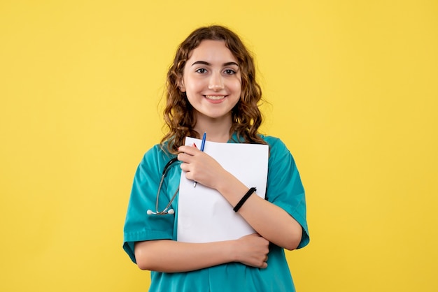 Vista frontal doctora en camisa médica con análisis de papel, uniforme de virus de salud, emociones pandémicas covid-19