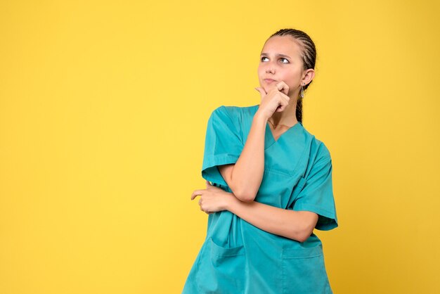 Vista frontal doctora en camisa médica, color del virus covid-19 de la enfermera de salud de la emoción