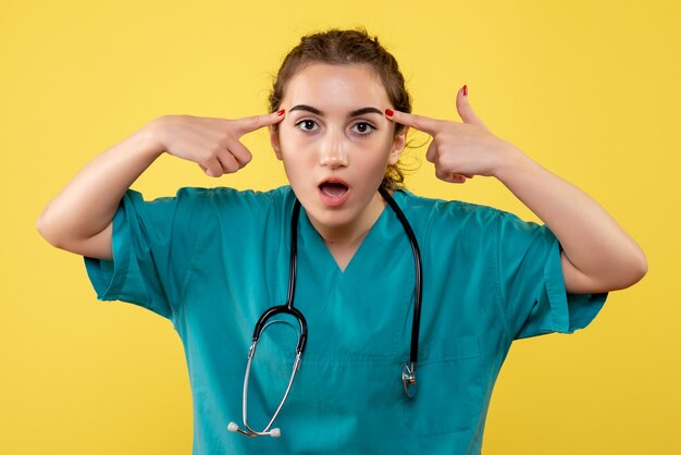 Vista frontal doctora en camisa médica, color virus pandémico covid-19 uniforme emoción salud