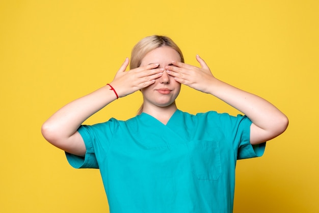 Vista frontal doctora en camisa médica cubriéndose los ojos, enfermera covid pandémica de emoción médica