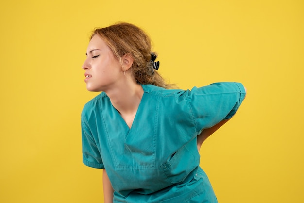 Foto gratuita vista frontal doctora en camisa médica con dolor de espalda, médico de salud covid-19 color enfermera del hospital