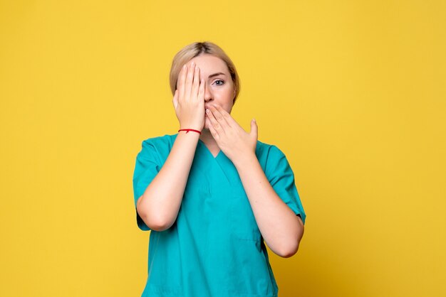 Vista frontal doctora en camisa médica, enfermera de covid pandémica de emociones de médico