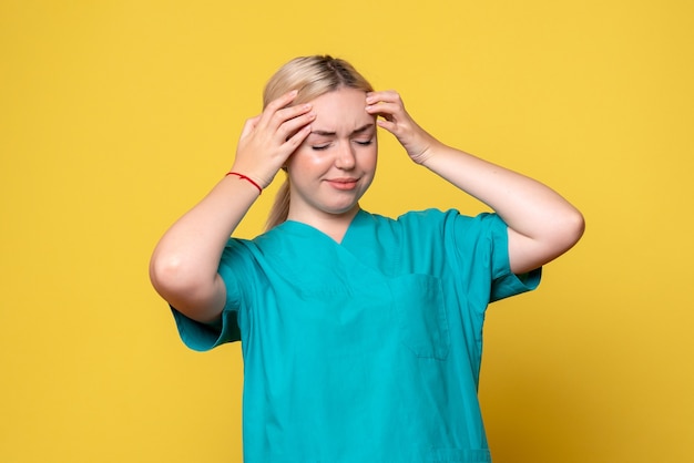 Vista frontal doctora en camisa médica con leve dolor de cabeza, enfermera pandémica covid-19 emoción medic