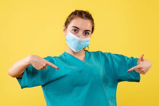 Vista frontal doctora en camisa médica y máscara estéril, color uniforme del virus de la salud emociones covid-19
