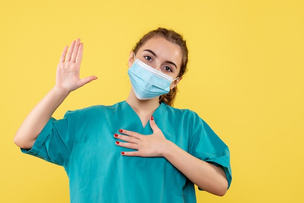 Vista frontal doctora en camisa médica y máscara estéril, enfermedad uniforme virus covid-19 salud pandémica