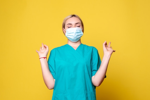 Vista frontal doctora en camisa médica y máscara estéril, enfermera del hospital médico de la pandemia covid-19