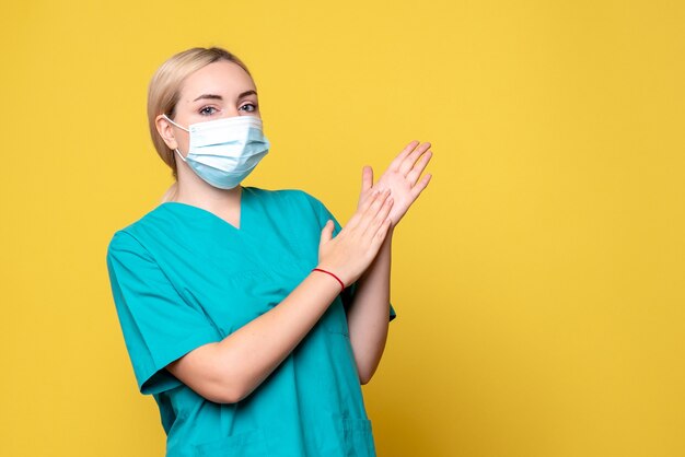 Vista frontal de la doctora en camisa médica y máscara estéril, médico de la pandemia de covid-19 de salud hospitalaria