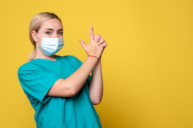 Vista frontal doctora en camisa médica y máscara estéril posando, enfermera médica del hospital salud pandémica covid