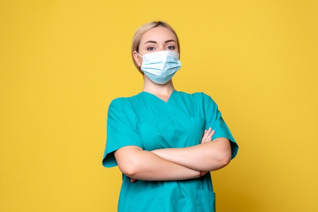 Vista frontal doctora en camisa médica y máscara estéril posando, enfermera médico de la pandemia covid-19