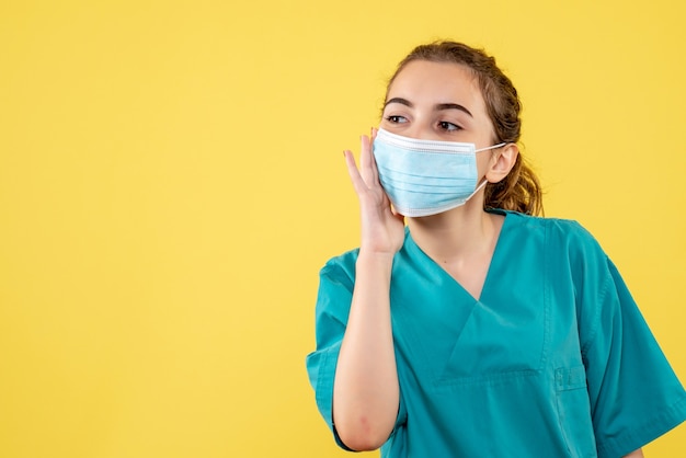 Vista frontal doctora en camisa médica y máscara estéril, virus color uniforme covid-