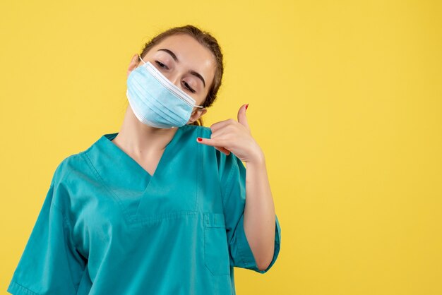 Vista frontal doctora en camisa médica y máscara estéril, virus de salud color uniforme covid-