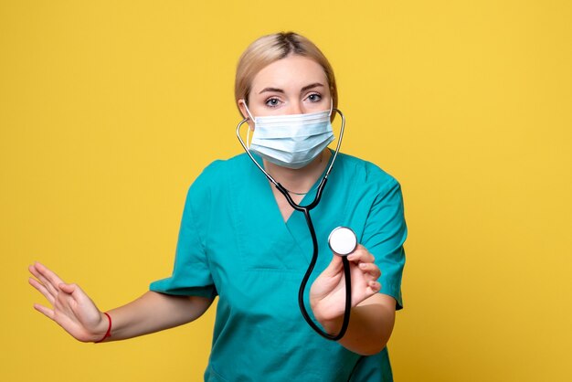 Vista frontal doctora en camisa médica y máscara con estetoscopio, enfermero médico covid-19 pandemia de salud