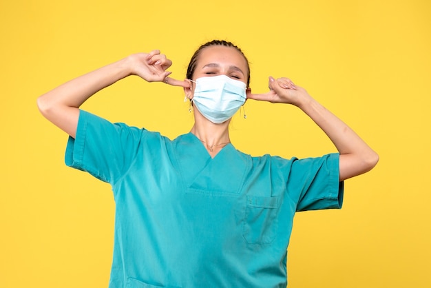 Foto gratuita vista frontal doctora en camisa médica y máscara con orejas pegadas, enfermera de salud hospital pandémica de virus covid-19 medic