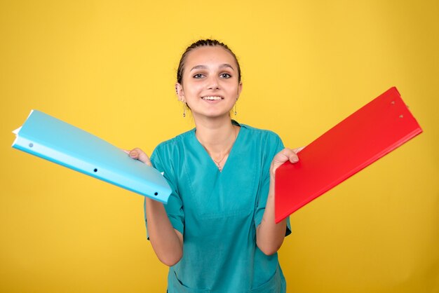 Vista frontal de la doctora en camisa médica con notas, color del hospital enfermera de salud médico covid-19 emoción